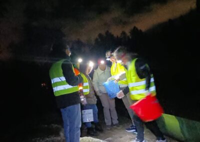 Volontari con frontali e pettorine durante una notte di salvataggio anfibi